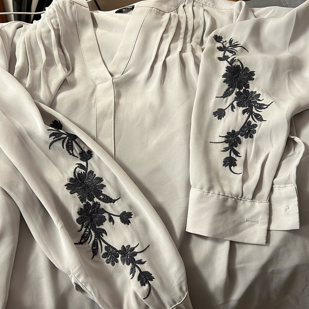 Grey pullover top with embroidery on sleeves. Like new. Never worn